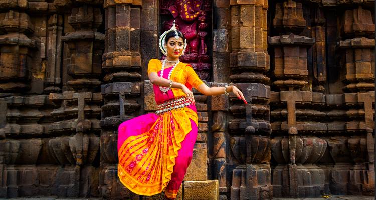 Traditional dancer posed in front of an ancient temple.