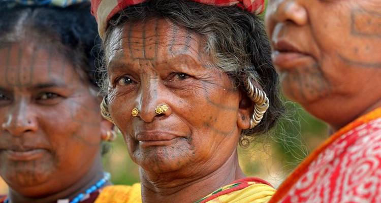 Group of women with facial tattoos and traditional dresses.