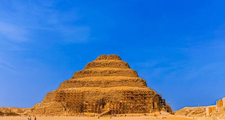 Pyramide à degrés antique sous un ciel bleu clair.