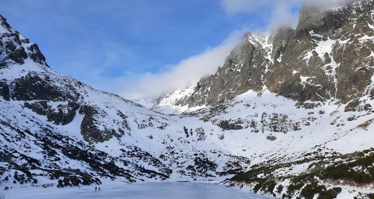 Snow-covered mountains with a frozen lake visible.