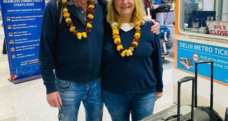 Two people with garlands standing at Delhi Metro station.