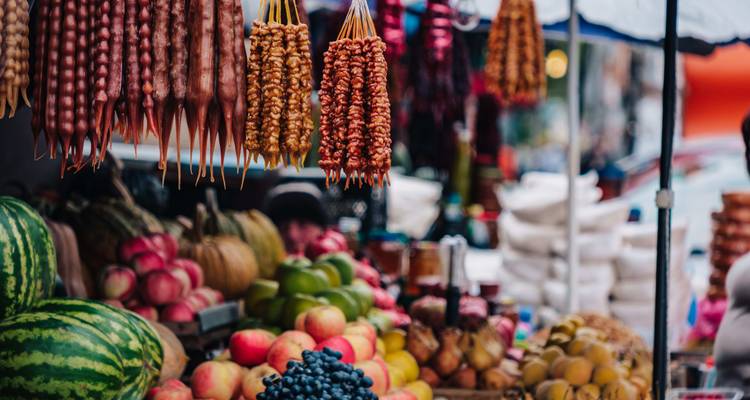 Kleurrijke uitstalling van fruit en Georgische snoepjes op een markt.