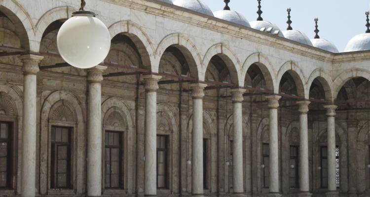 Extérieur d'un bâtiment historique avec une rangée d'arches et de tours.