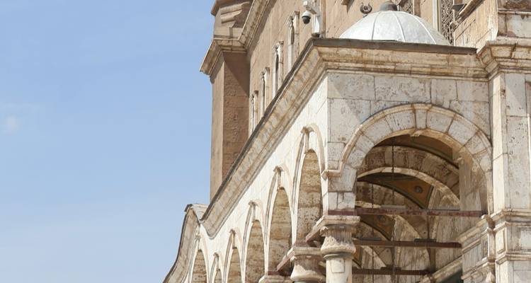 Vue partielle d'un bâtiment historique avec des arches et un dôme.