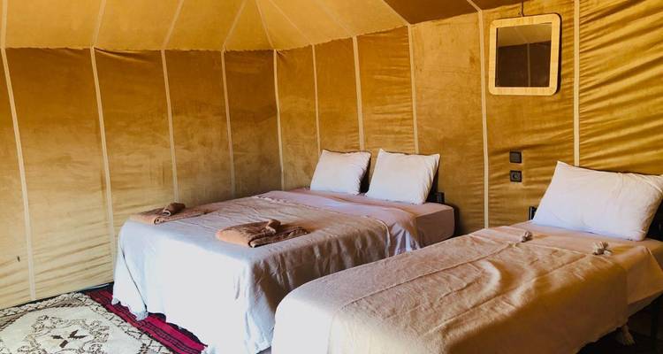 Interior of a traditional tent accommodation with two beds.