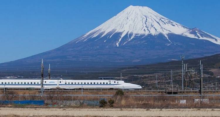 Hogesnelheidstrein die langsrijdt voor de berg Fuji.