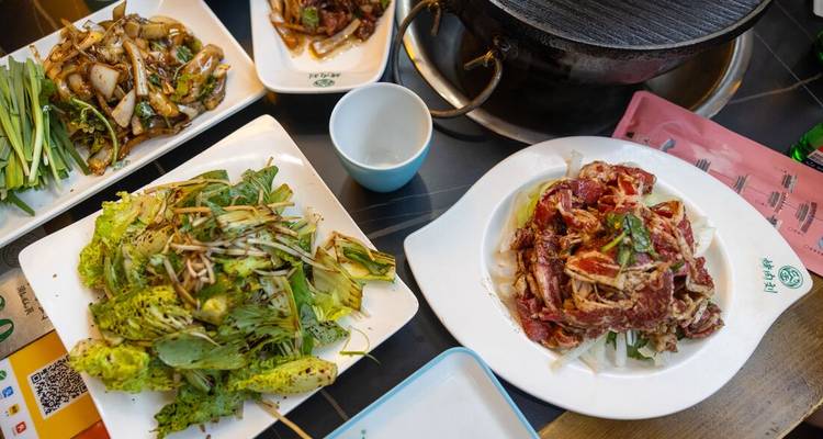 Platos de comida exhibidos en una mesa, probablemente cocina china.