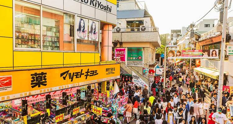 Crowded shopping street with colorful signs and stores.