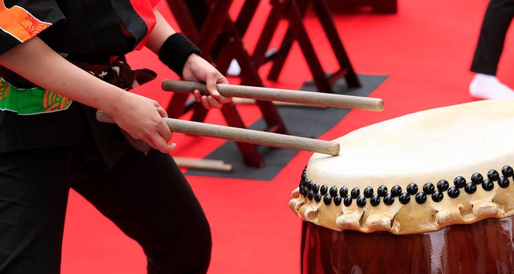 Person playing a traditional Japanese drum.