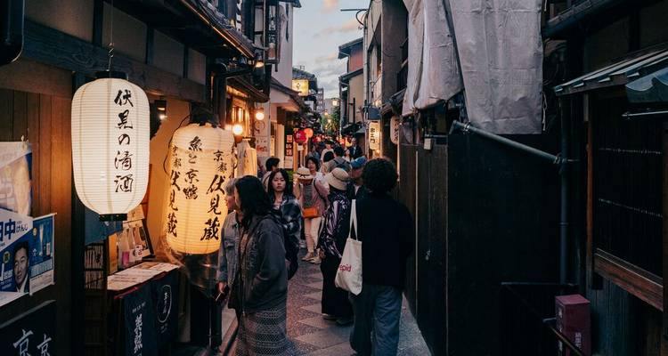 Crowded traditional street with shops and lanterns in the evening.
