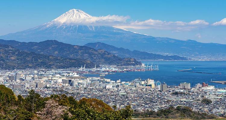 Le majestueux mont Fuji couronné de neige dominant la ville côtière et le port par une journée claire.