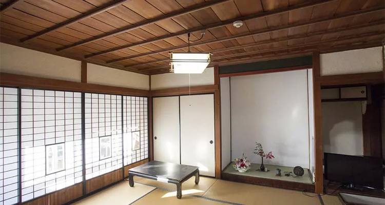 Pièce japonaise traditionnelle simple avec tatamis, paravents shoji et table basse.