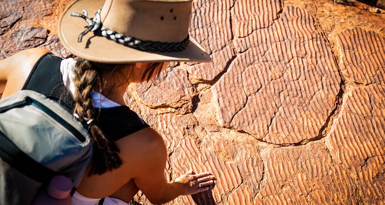 Person examining textured rock formations.