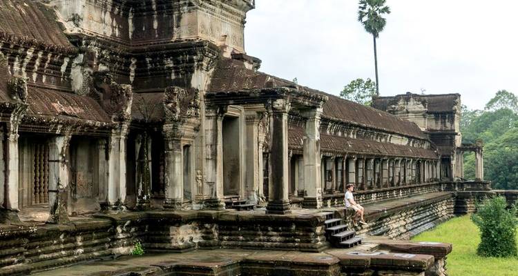 Personne assise sur les marches d'un temple historique.