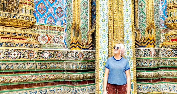 Person standing in front of a detailed, colorful temple.