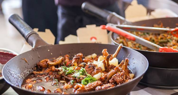 Fried dish being prepared with vegetables in a wok.