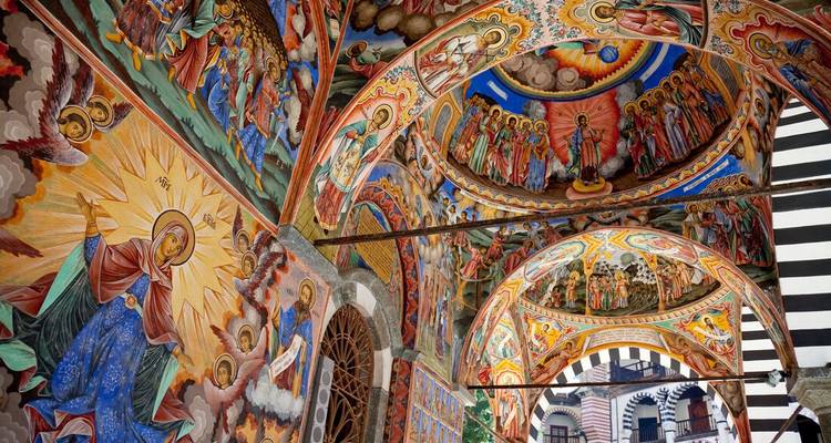 Des fresques et œuvres d'art complexes ornent le plafond intérieur d'une église.