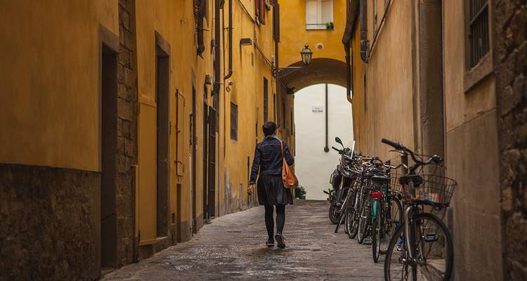 Personne marchant dans une ruelle avec des vélos.