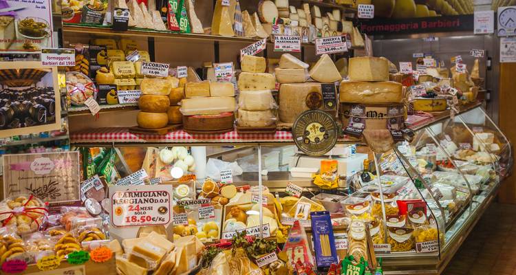 Étalage de marché de fromages avec différents types de fromage.