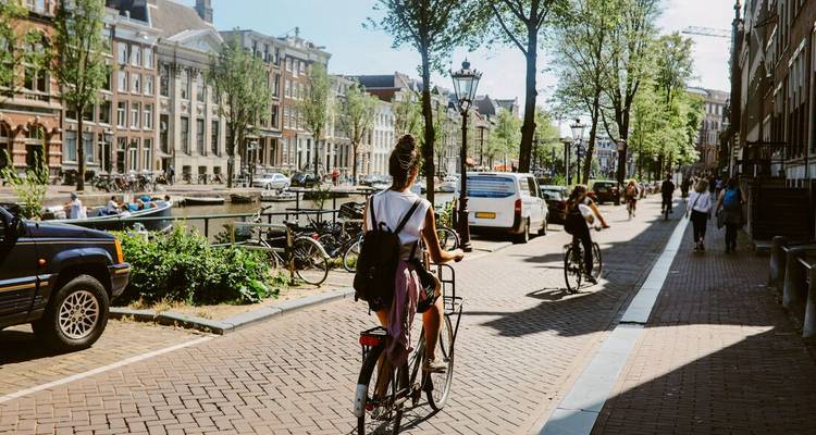 Cycliste dans le paysage urbain d'Amsterdam avec canal.
