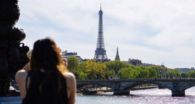 Eiffel Tower in the background with person taking a photo.