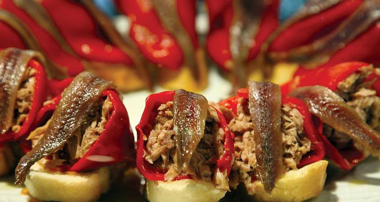Stuffed red peppers with anchovies on a plate.