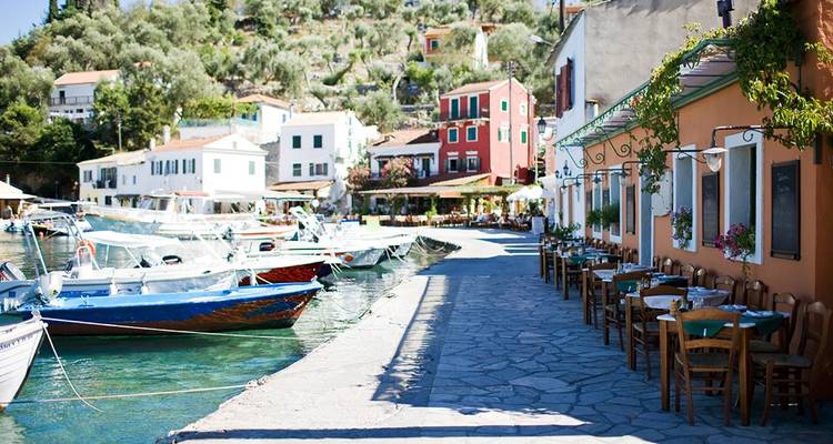 Colorful coastal village with boats along the waterfront.