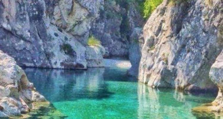 Eau turquoise claire entre des falaises rocheuses.