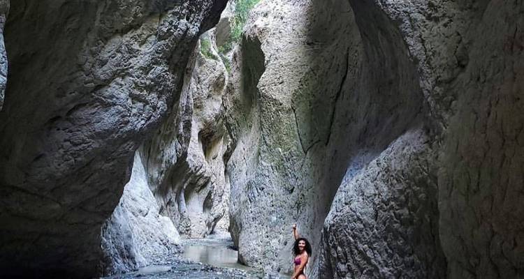 Personne explorant une gorge rocheuse étroite.