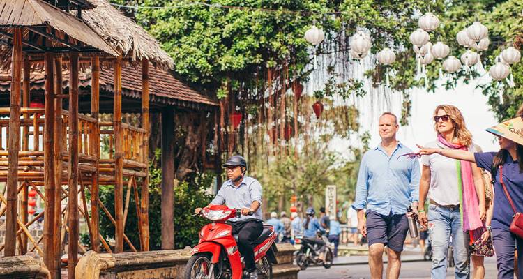 Groupe diversifié naviguant sur un bateau dans une voie navigable luxuriante.