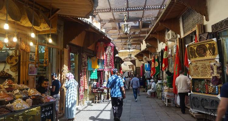 Gente caminando por una calle de mercado bulliciosa.