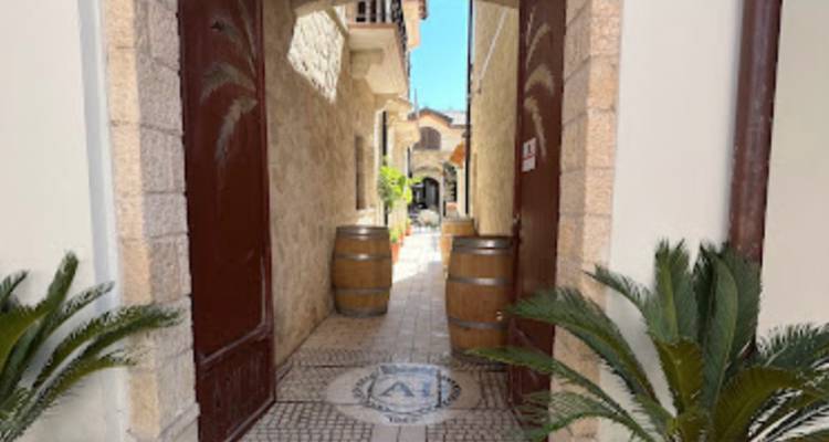 Ruelle étroite avec des tonneaux et une vue sur l'architecture historique.