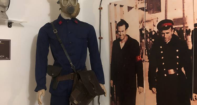 Un mannequin en uniforme bleu avec un masque à gaz dans un musée.