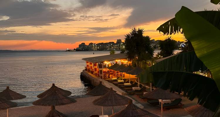Bar en bord de mer avec vue sur le ciel coucher de soleil et l'horizon urbain.