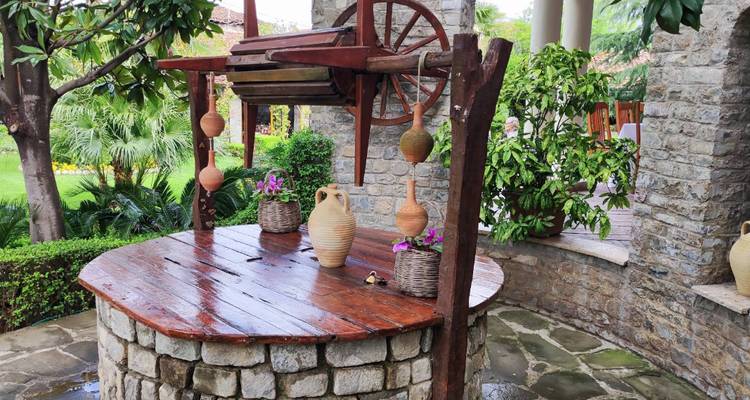 Installation traditionnelle de puits avec poterie sous une structure ombragée.