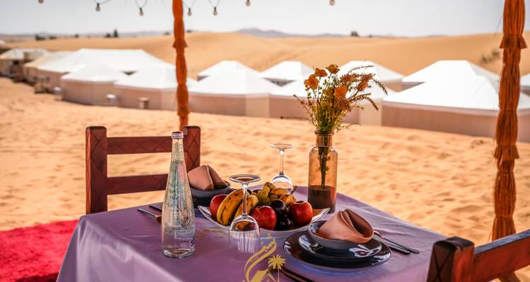 Luxurious outdoor dining setup in a desert camp.