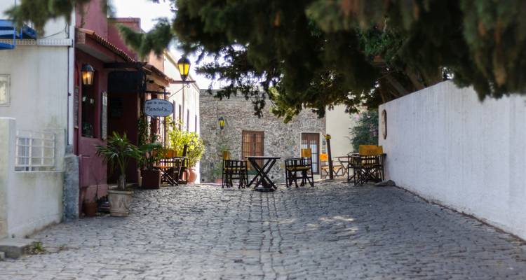 A quiet cobbled street with cafes in a historical setting.