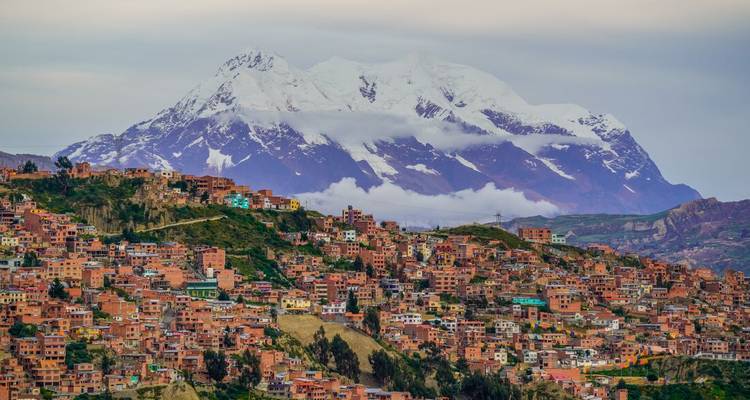 A panoramic view of a city with colorful buildings against a mountainous backdrop.