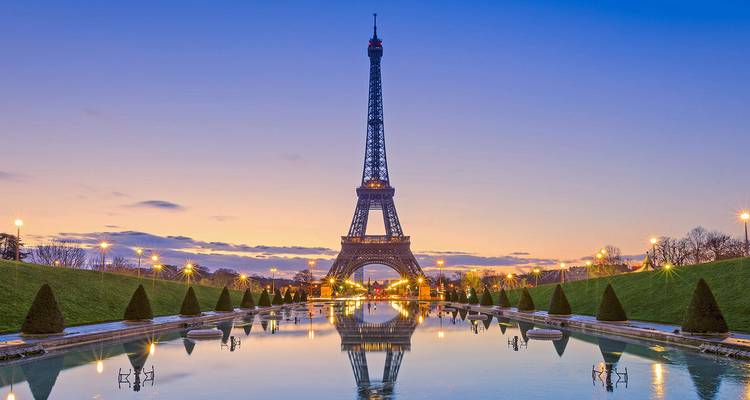 Tour Eiffel avec un environnement magnifiquement illuminé au crépuscule.