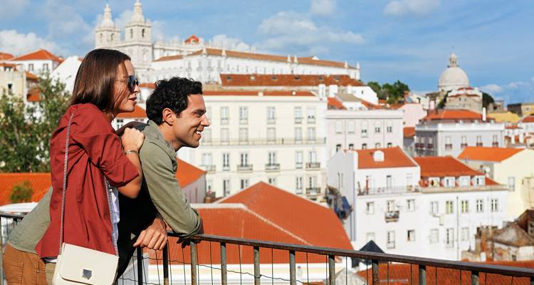 Stel geniet van het uitzicht op een stad met witte gebouwen en rode daken.