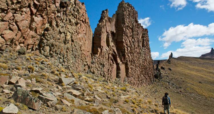 Person hiking towards large rock formations.