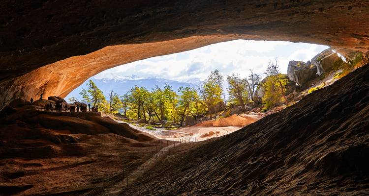 View from inside a cave with a sunny landscape outside.