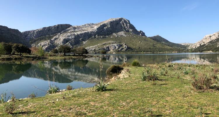 Tranquil lake with reflections of surrounding mountains.