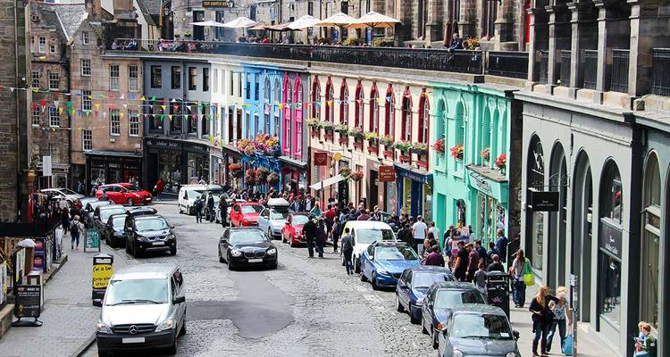 Rue animée avec des maisons colorées et des gens à Édimbourg.