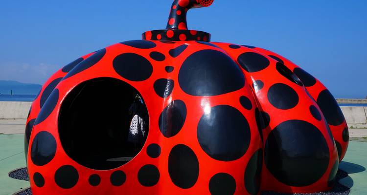 Sculpture à pois rouge et noire d'une structure ressemblant à une citrouille.