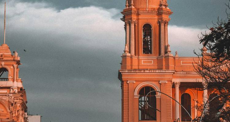 Architecturale details van twee oude gebouwen tegen een stormachtige hemel.
