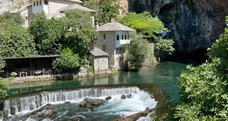 Bâtiments en pierre près d'une petite cascade et d'une rivière.