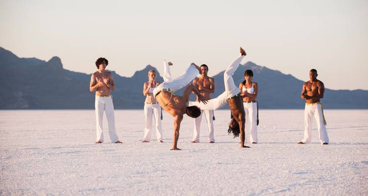 Des personnes pratiquant la capoeira sur un lac de sel.