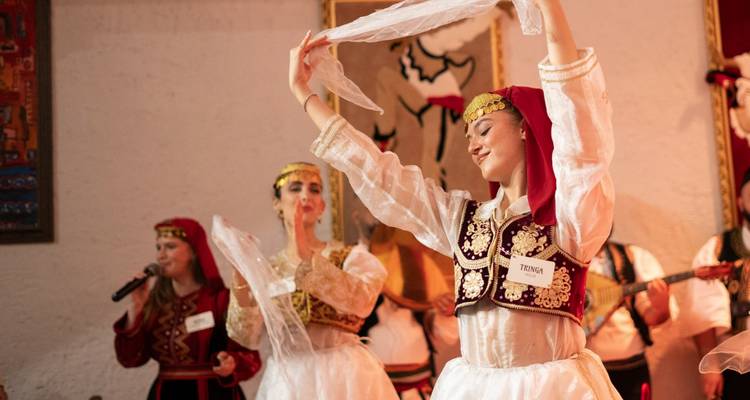Un groupe de femmes en costumes traditionnels albanais exécutant une danse.