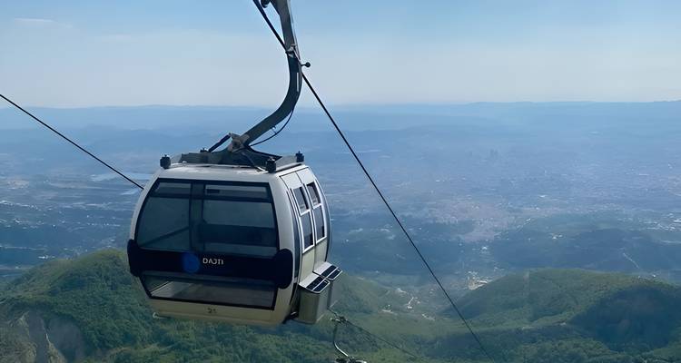 Un téléphérique suspendu dans les airs au-dessus d'un paysage montagneux.